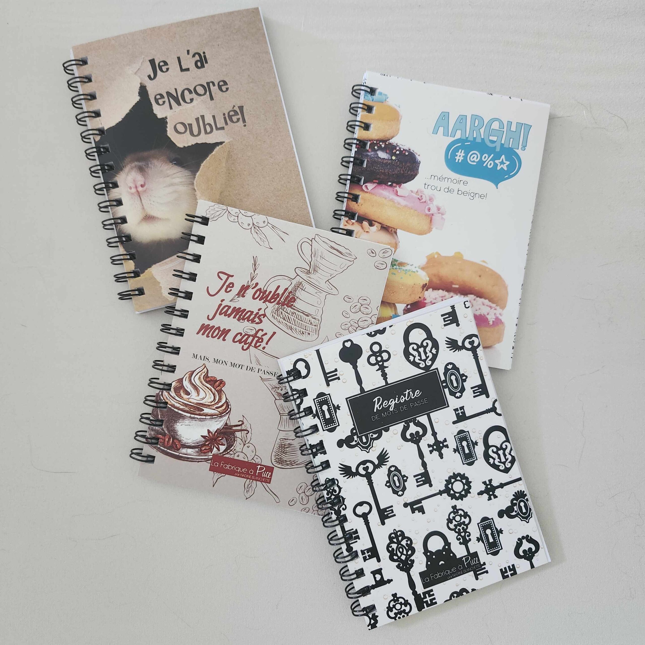 Carnet de mots de passe Papeterie Nadine Blanchette avec motifs graphiques noirs et rouges, accompagné de fournitures de bureau.