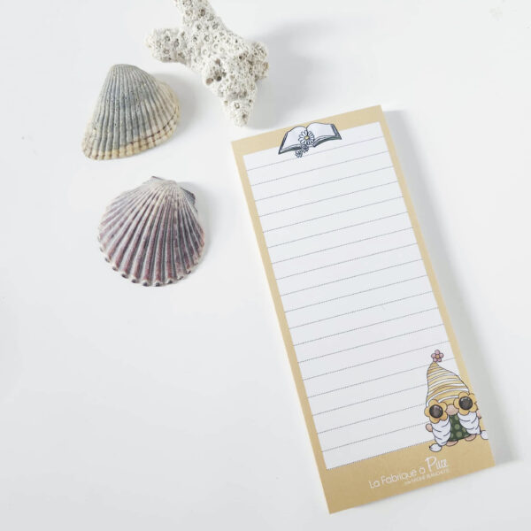 Bloc-notes aide-mémoire – Collection Gnomes posé sur une planche de bois avec des coquillages décoratifs